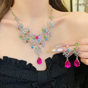 Détail d'une parure florale vintage avec pendentifs goutte roses et cristaux colorés