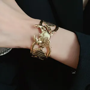Close-up of vintage gold crab and seashell hollow-out open bangle bracelet for women
