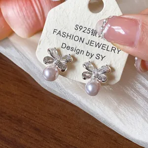 Detailed view of elegant silver butterfly pearl earrings with sparkling zircon stones