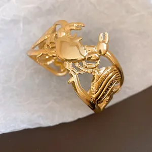 Macro view of gold vintage cuff bracelet with crab and fish hollow patterns