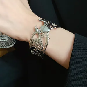 Close-up of silver metal cuff bracelet with hollow-out crab and fish design