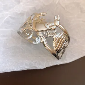 Detailed macro view of silver metallic crab and fish hollow open cuff bracelet design