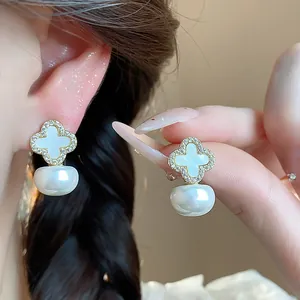 Detailed macro view of elegant four-leaf clover stud earrings with zircon inlay and pearls