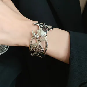 Detailed view of a vintage silver metal crab and seashell hollow open cuff bracelet on wrist