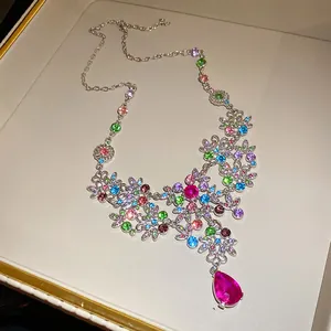 Vue détaillée d'un collier floral vintage avec strass colorés et pendentif en goutte.