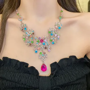 Gros plan d'un collier vintage à fleurs orné d'un grand pendentif en goutte rose