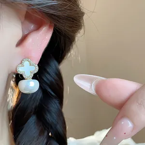 Close-up detail of elegant zircon flower pearl earrings worn on ear with French chic style