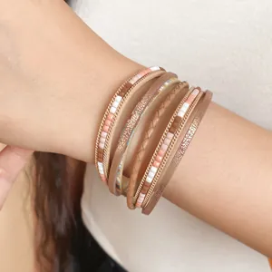 Vista macro dettagliata di bracciali a strati stile Maillard con pelle e oro