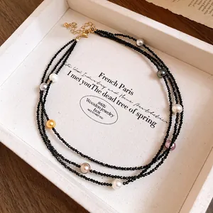 Close-up of a multi-layer black beaded necklace with colorful pearls in a display tray