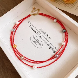 Detailed view of a multi-layer red beaded necklace featuring various colorful pearls