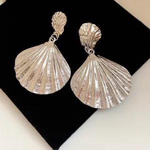 Detailed macro shot of vintage silver shell drop earrings with elegant metallic crinkle texture
