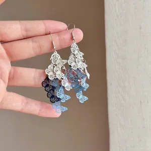 Detail of gradient blue hollow butterfly drop earrings with delicate painted finish