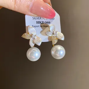 Detailed view of elegant flower-shaped earrings with white pearls and S925 silver base