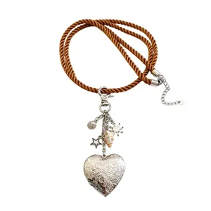 Vintage bohemian brown cord necklace featuring a silver heart locket and sea charms