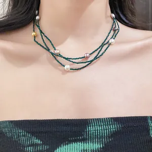 Elegant multi-layer green beaded necklace with colorful pearls worn on a model's neck
