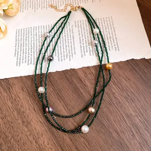 Detailed macro shot of an elegant multi-layer necklace featuring green beads and pearls