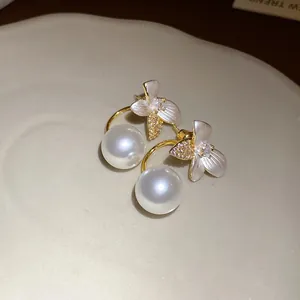 Close-up of elegant floral pearl stud earrings with sparkling crystal pave petals