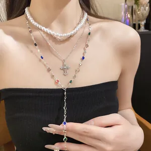 Dreilagige silberne Halskette mit Harzperlen und Strass-Kreuzanhänger am Modell.