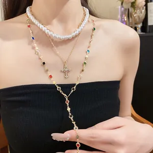 Detailansicht eines mehrlagigen Halsketten-Sets mit Harzperlen und Diamantkreuz