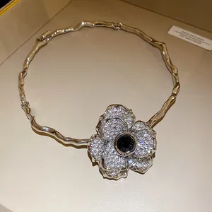 Gros plan d'un ras-du-cou floral en strass avec un design de branche argentée bijoux