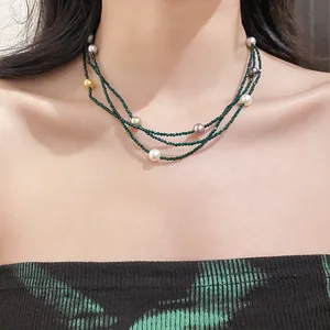 Detail view of an elegant multi-layer beaded necklace with colorful pearls worn by a model.