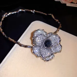 Gros plan détaillé d'un collier ras du cou en strass avec fleur argentée et gemme noire