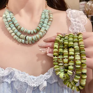 Detail of multilayer shell beaded necklace and bracelet set in refreshing green tones.