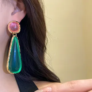 Detailed close-up showing vintage resin drop earrings with pink and green stones on model