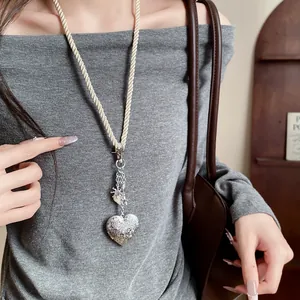 Vintage silver heart pendant necklace with cream rope cord and shell detail detail view
