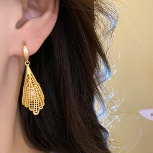Elegant gold filigree earrings with pearls and zircon accents shown worn on ear details.