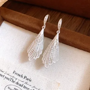 Detailed view of elegant silver lace-pattern drop earrings with zircon embellishments
