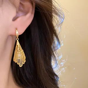 Close-up detailed view of elegant hollow lace gold earring with pearl and zircon inlay