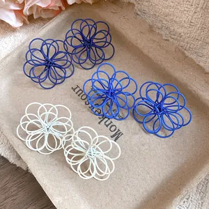 Detailed macro view of hollow wire-wrapped flower stud earrings in three vibrant colors