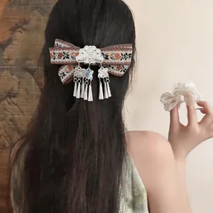 Detailed view of a vintage Bohemian ribbon hair clip featuring elegant metallic tassels