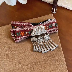 Close-up of vintage Bohemian ribbon hair clip with ethnic tassel details