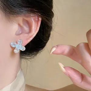 Primer plano de pendientes de flor de circón brillante con diseño de pin de plata