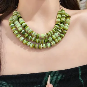 Close-up detail of a vibrant three-layer green shell disc bead necklace for women.