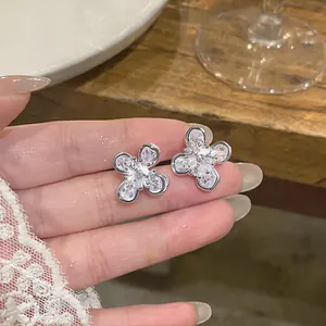 Vista detallada de pendientes de botón de flor con circonitas y acabado plateado