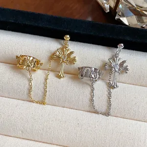Close-up of 18k gold and silver plated zircon cross ear cuffs with chains