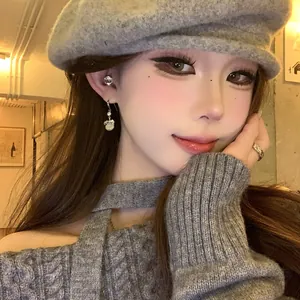 Close-up of elegant circular resin drop earrings with rhinestone details on a female model