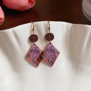 Detail showing pink Bohemian diamond drop earrings with intricate floral relief patterns