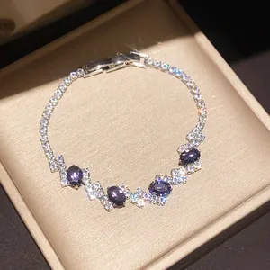 Macro detail of a sparkling silver bracelet with purple and clear zircon stones in a gift box