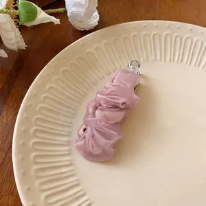 Squisito fermaglio per capelli in chiffon rosa, accessorio per capelli in tessuto su un piatto