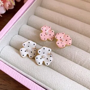 Elegant polka dot flower stud earrings with pearls displayed in a pink jewelry box