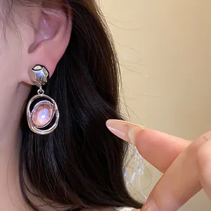 Close-up detail of vintage acrylic oval pendant earrings featuring a stylish silver finish