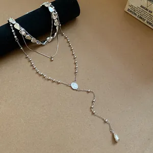 Close-up of silver layered necklace set with irregular water drop pendants.