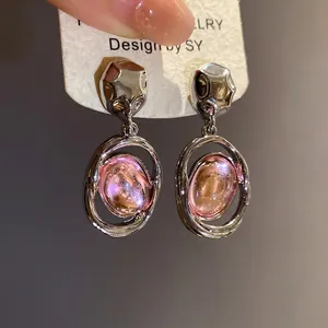 Detailed view of vintage pink acrylic oval dangle earrings with silver-tone metal finish