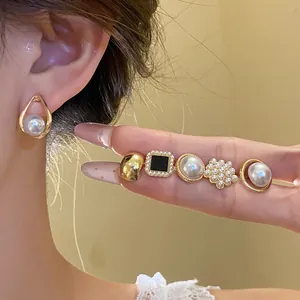Detailed view of elegant vintage pearl and cat eye stone earring set worn by a model