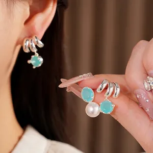 Elegant silver hoop earrings with blue gemstone and white pearl drop on model