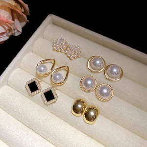 Vintage set of 5 pairs pearl and gold-tone stud earrings displayed in a jewelry box